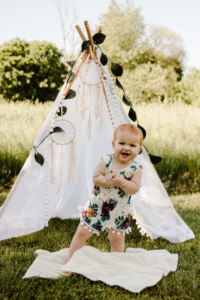 baby in front of teepee tent for outdoor cake smash session