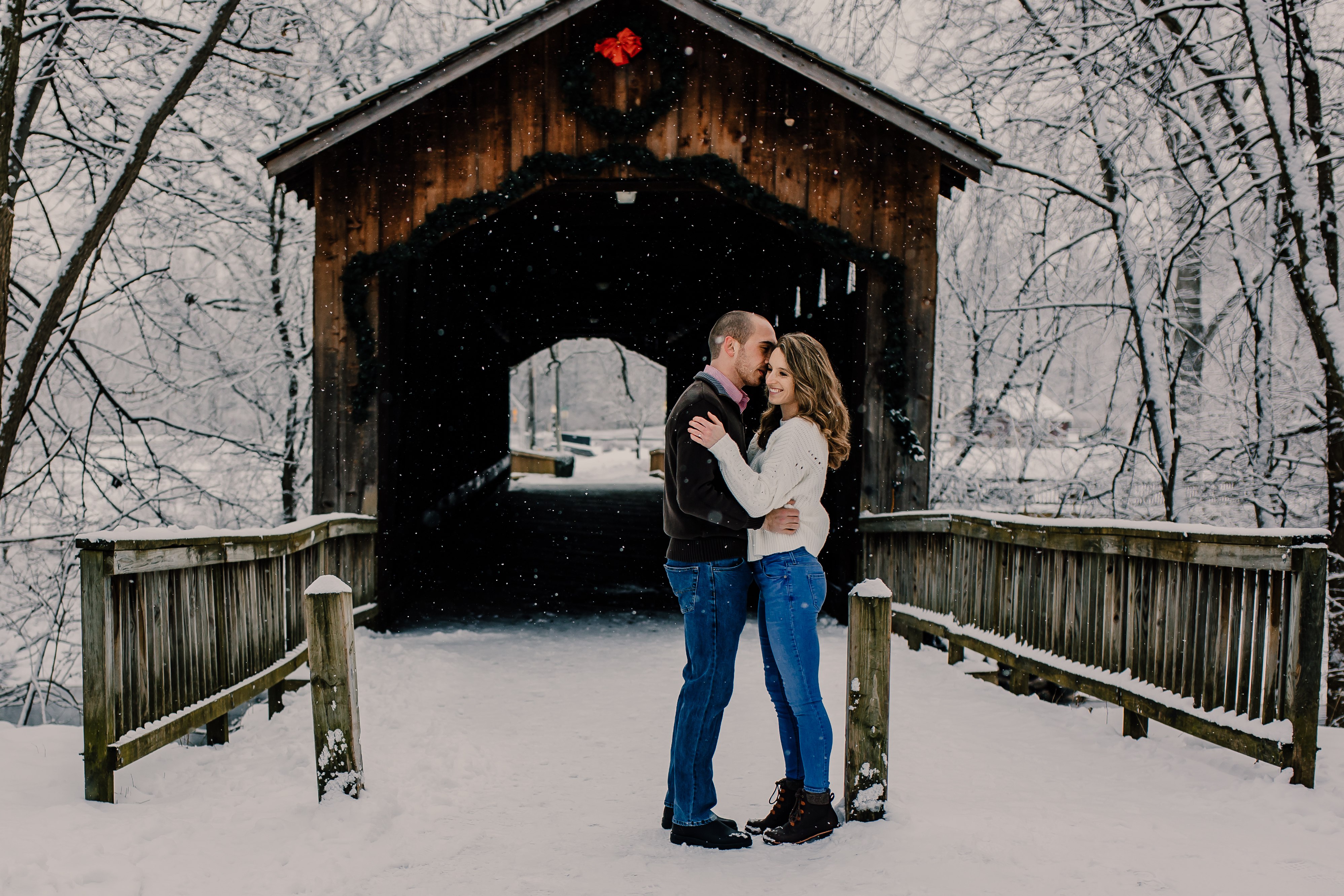 couple hugging by covered bridge