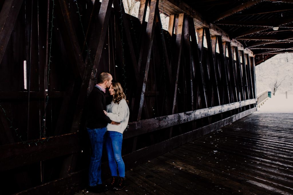 couple holding each other under covered bridge