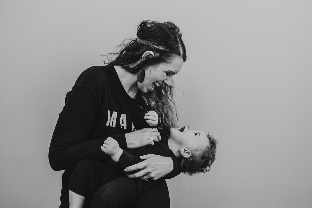 mom and one year old son holding each other